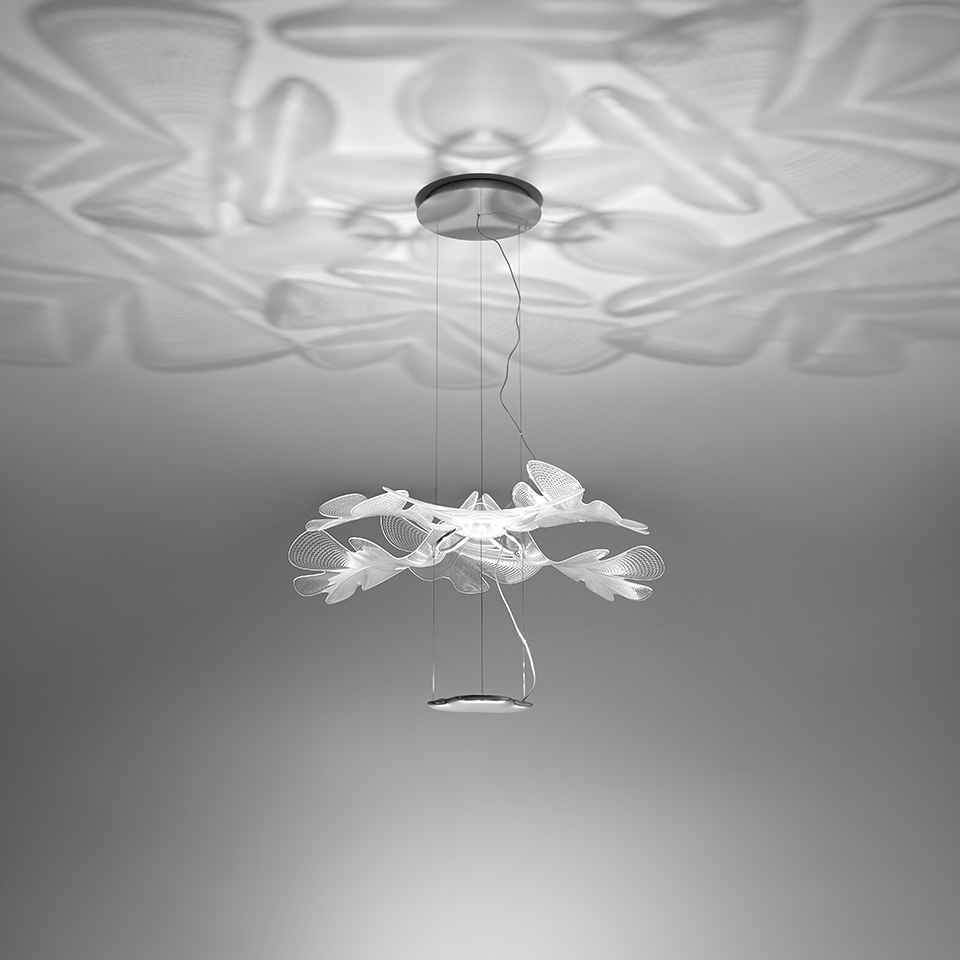 Artemide Chlorophilia pendant lamp with translucent leaf-shaped diffusers arranged in a circular crown, casting organic floral patterns on the ceiling