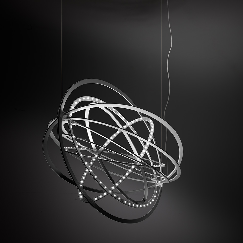 Artemide Copernico suspension lamp: multiple interlocking metallic rings with LED strips forming a spherical orbital structure, hung by thin cables