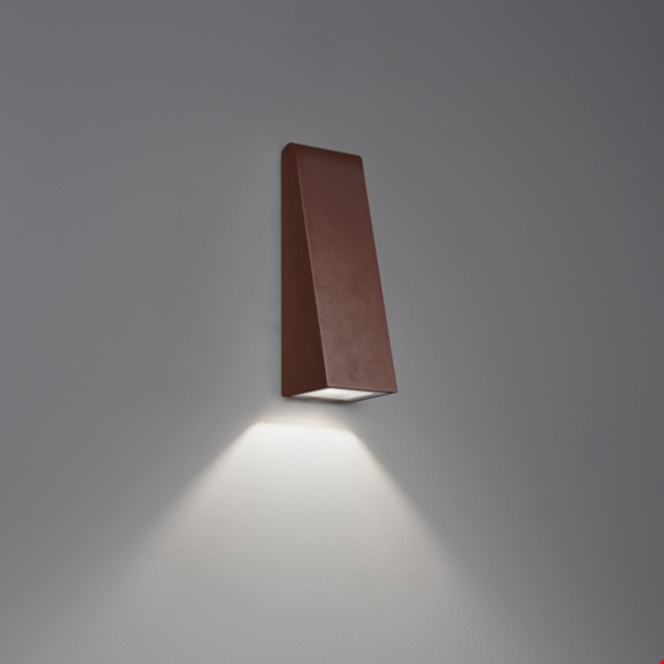 Artemide Cuneo wall lamp in corten finish, angular trapezoidal body emitting downward LED light beam on neutral wall
