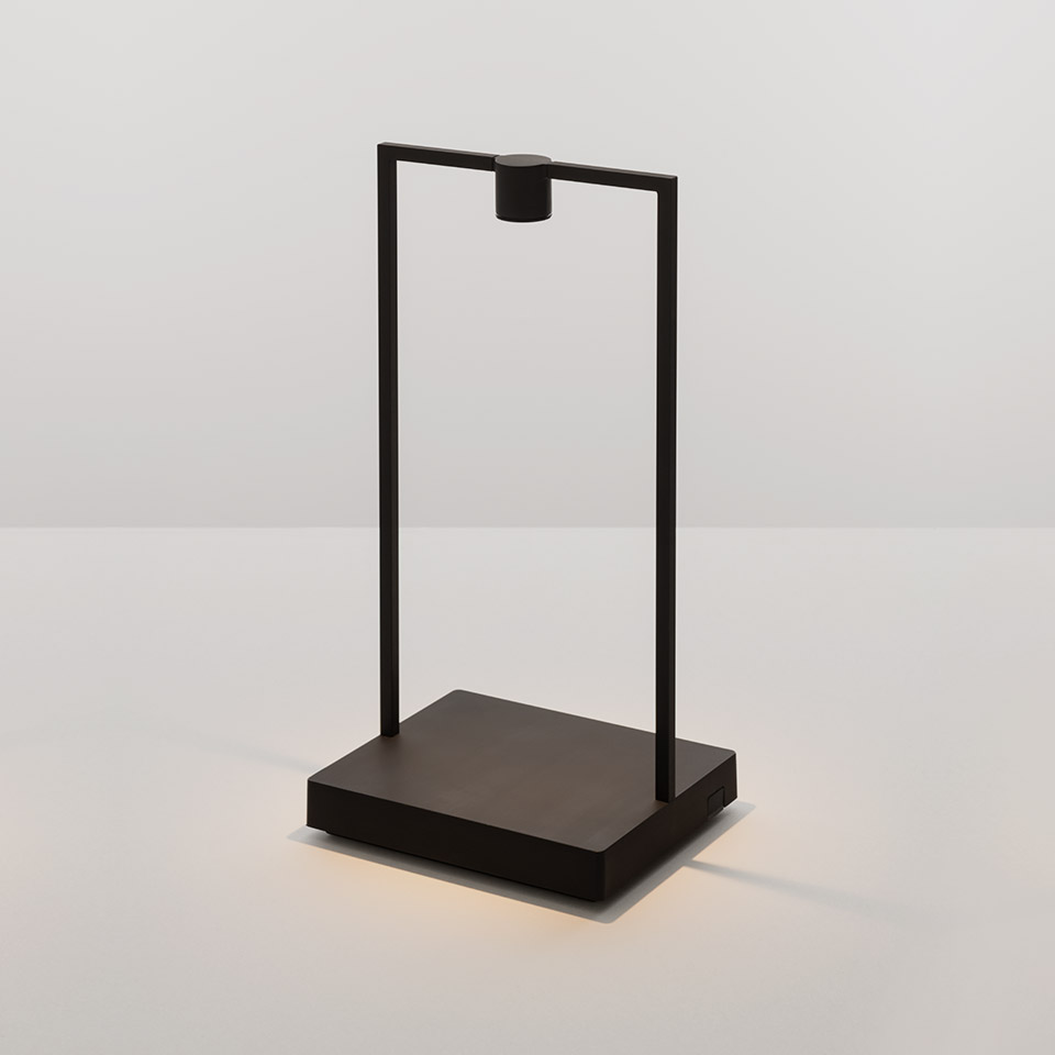 Artemide Curiosity table lamp: minimalist black rectangular frame with downward LED spotlight mounted on a square weighted base
