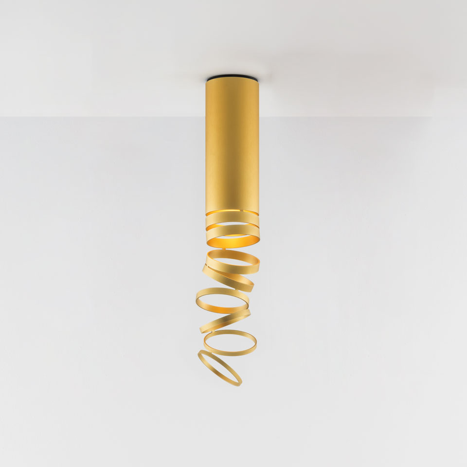 Artemide Decomposé Light Soffitto ceiling lamp in gold, featuring a cylindrical body with a spiraling ribbon shade descending from it