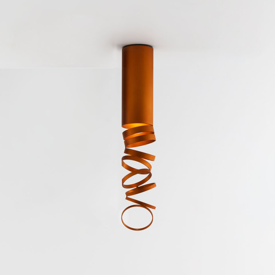 Artemide Decomposé Light Soffitto ceiling lamp in orange, featuring a cylindrical body with a spiraling ribbon-like metal diffuser