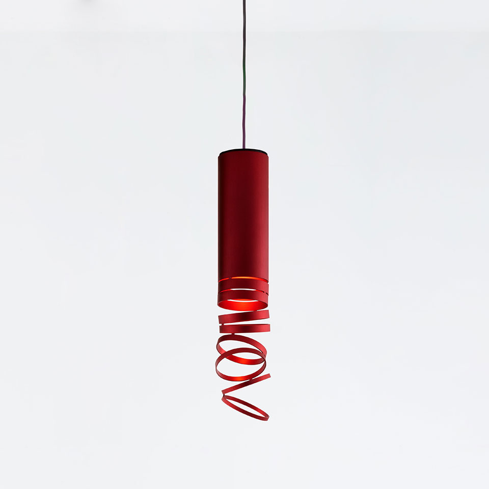 Artemide Decomposé Light pendant lamp in red, featuring a cylindrical body with a spiraling ribbon diffuser at the bottom