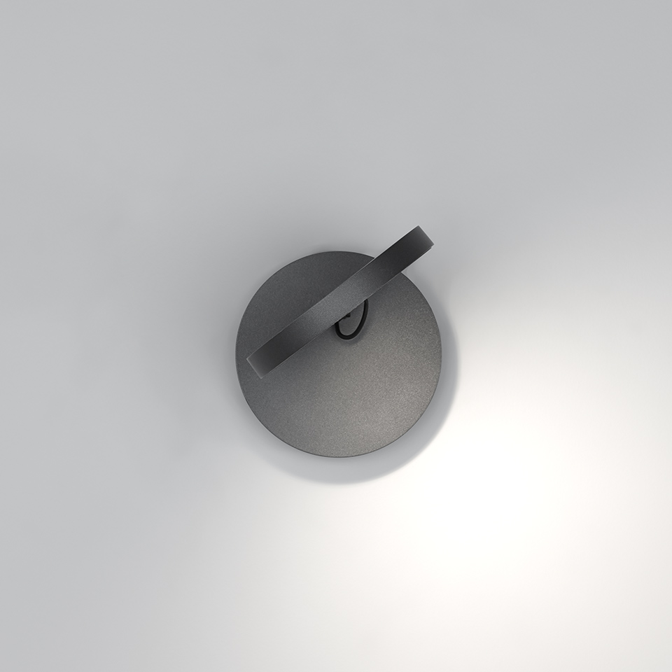 Artemide Demetra Faretto wall spotlight in anthracite, circular base with adjustable arm, emitting focused downward light