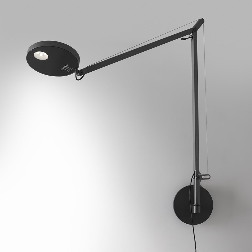 Artemide Demetra Parete wall lamp in black, featuring an adjustable articulated arm and circular LED head mounted on a wall bracket