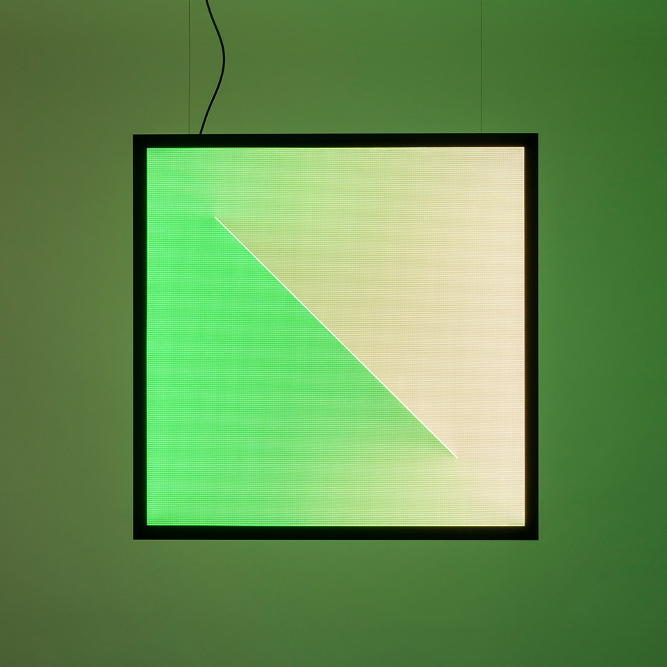 Artemide Discovery Dialogue square pendant lamp with black frame, displaying a diagonal split of green and warm white light panels