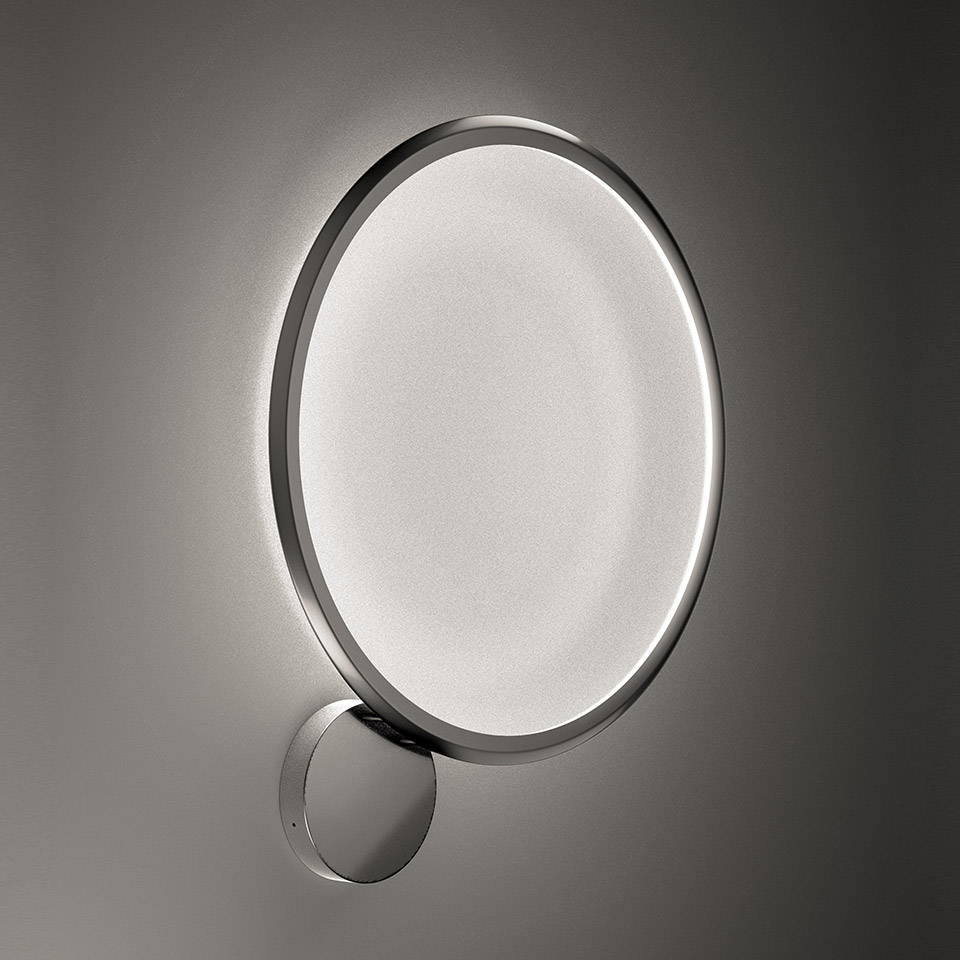 Artemide Discovery Parete wall lamp: large circular LED diffuser with metallic ring frame, emitting soft backlight glow, mounted on wall