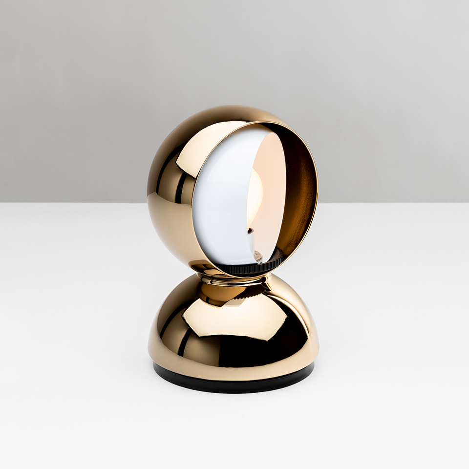Artemide Eclisse table lamp in gold finish, featuring a rotating spherical shade on a dome-shaped base for adjustable light