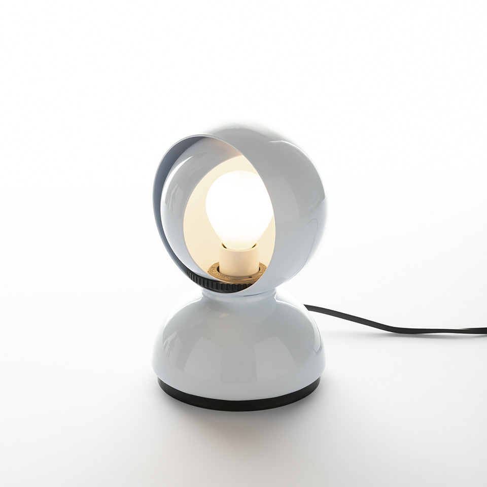 Artemide Eclisse table lamp in white, featuring a rotating spherical shade on a round base, with a visible bulb and black power cord