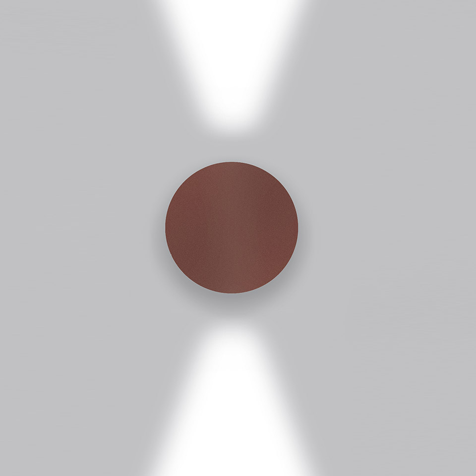 Artemide Effetto wall lamp in burgundy red, emitting two focused beams of light upward and downward against a white wall