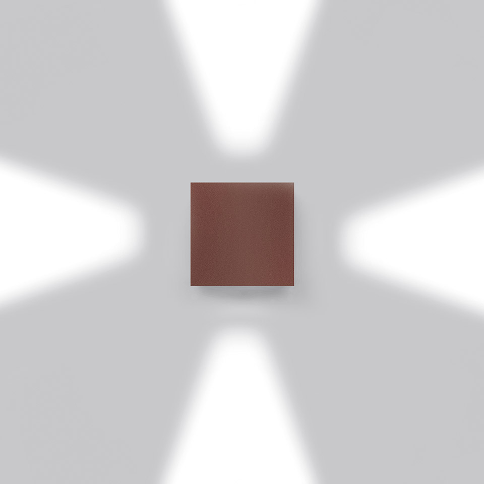 Artemide Effetto wall light in brown finish, projecting four beams of light upward, downward, and sideways on a white wall