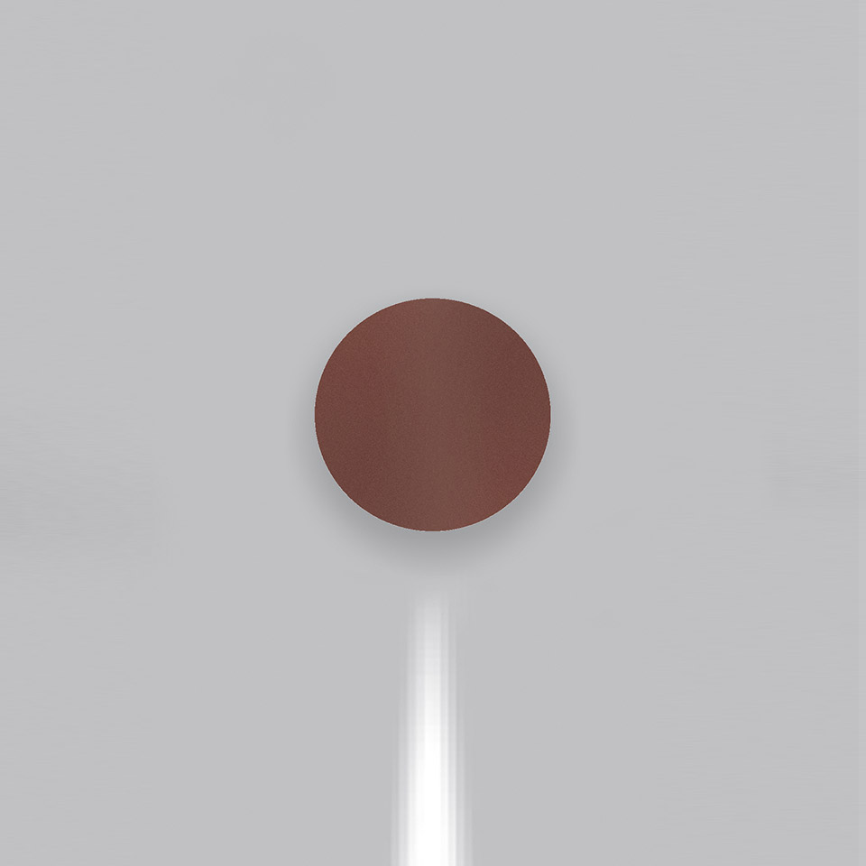 Artemide Effetto wall lamp in terracotta red, circular disc shape, emitting a focused downward beam of white light