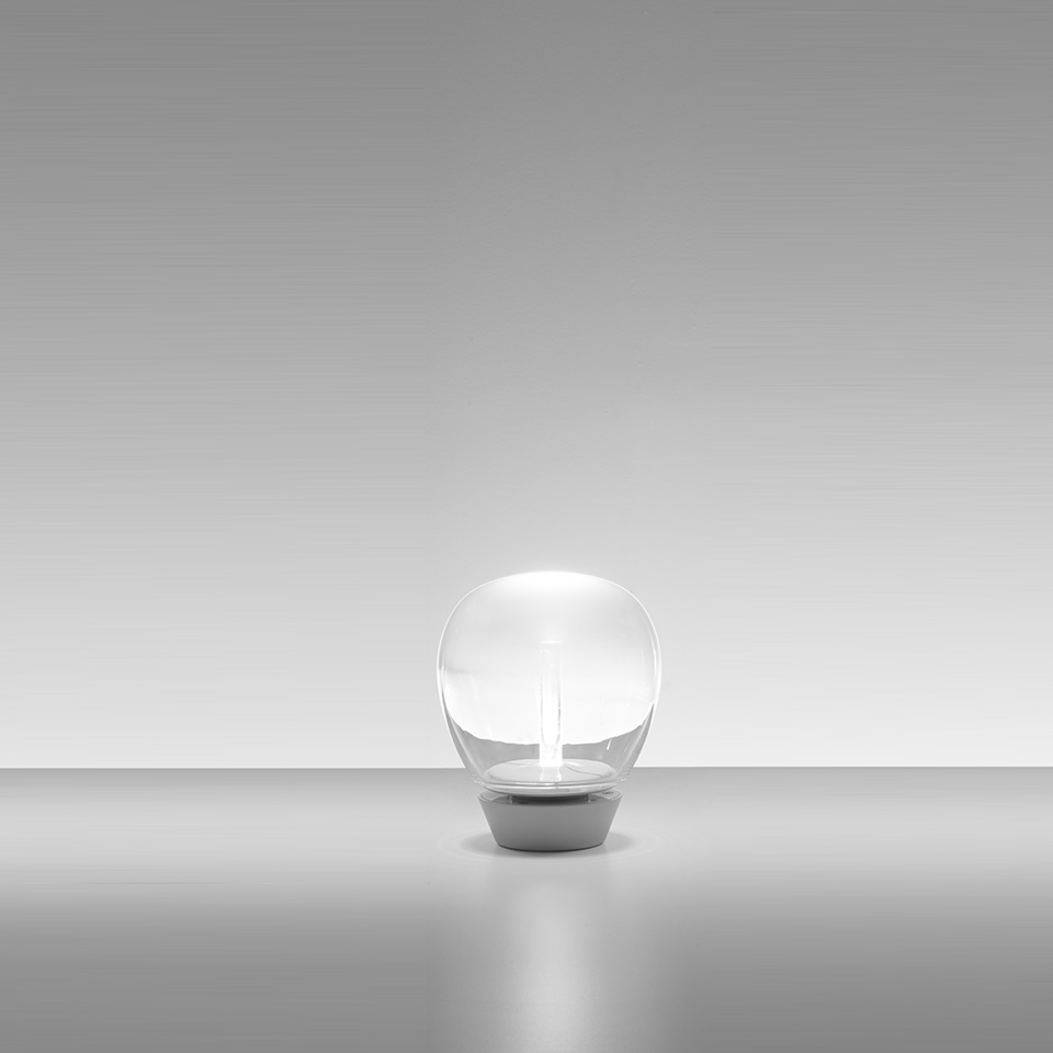 Artemide Empatia table lamp: transparent spherical glass diffuser with central LED stem on a compact white base