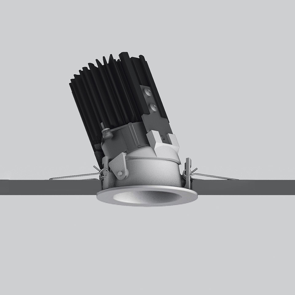 Artemide Everything 55 recessed spotlight with tilted black heat sink, silver round trim, and spring clips for ceiling installation