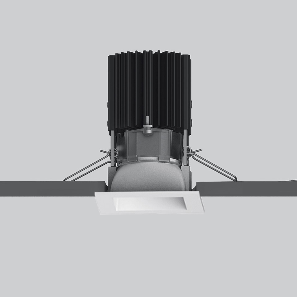Artemide Everything 55 square recessed LED downlight in white, with black finned heat sink, shown during ceiling installation