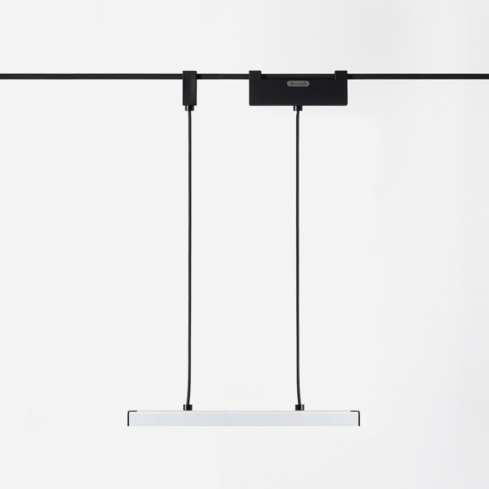 Artemide Funivia pendant lamp: slim white linear LED bar suspended by two black cables from a black track-mounted adapter