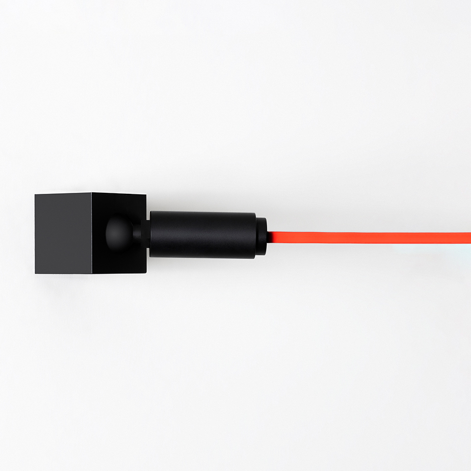 Artemide Funivia Plug wall lamp: black square wall mount with cylindrical body emitting a thin red cable horizontally