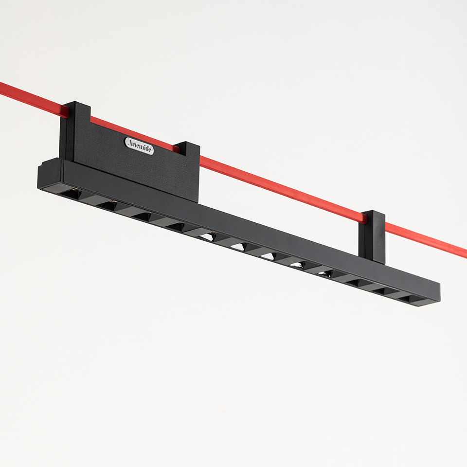 Artemide Funivia linear LED track light in black, with multiple spotlights, suspended from a red cable system
