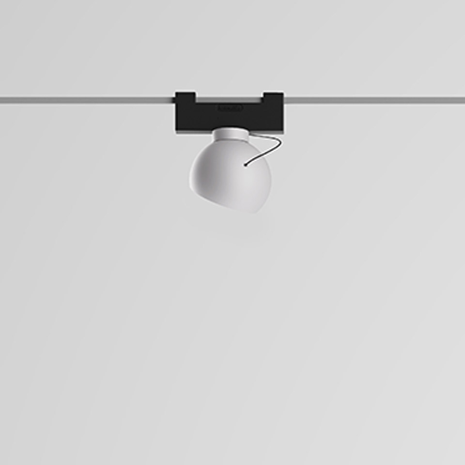 Artemide Funivia track spotlight with white spherical diffuser mounted on a black track adapter, adjustable directional light