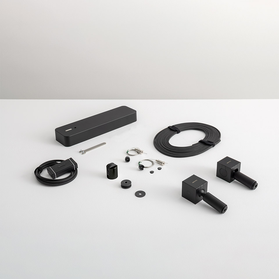 Artemide Funivia system installation kit: black components including power box, cable, connectors, mounting hardware, and track end caps - 2