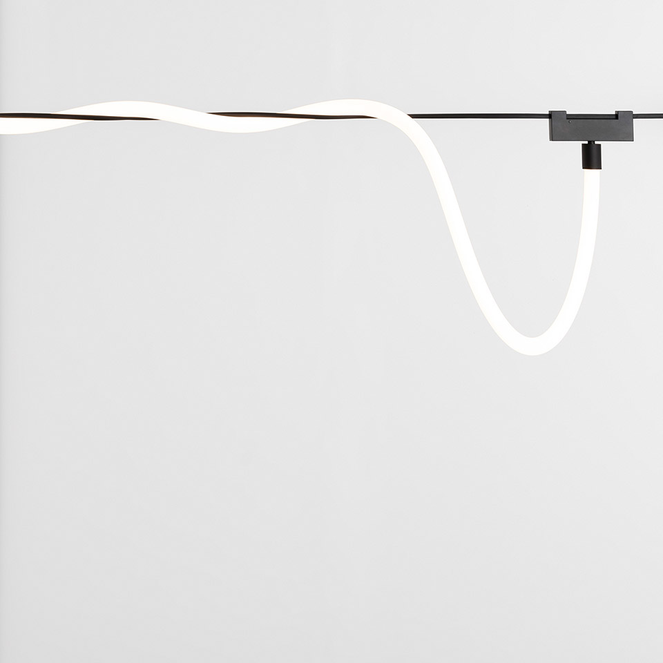 Artemide Funivia: flexible white LED neon tube suspended on a cable system with a dark metal bracket mount - 2