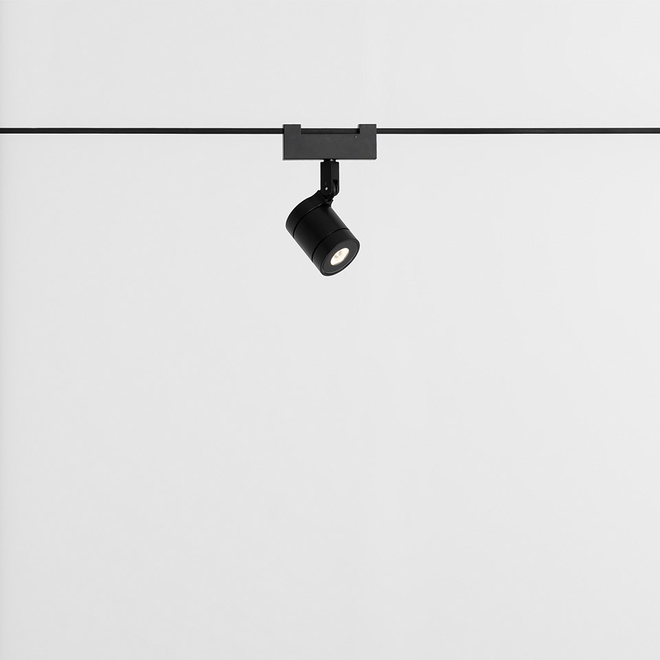 Artemide Funivia track spotlight: black cylindrical LED spot mounted on a slim cable track, adjustable head for directional lighting
