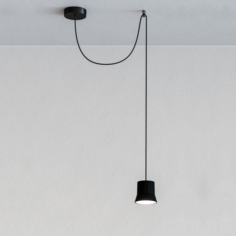 Artemide Giò Light Decentrata: black pendant lamp with truncated cone shade hanging from an off-center ceiling canopy on a black cord