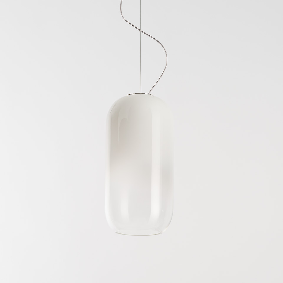 Artemide Gople pendant lamp: elongated capsule-shaped white opal glass diffuser suspended by a thin steel cable