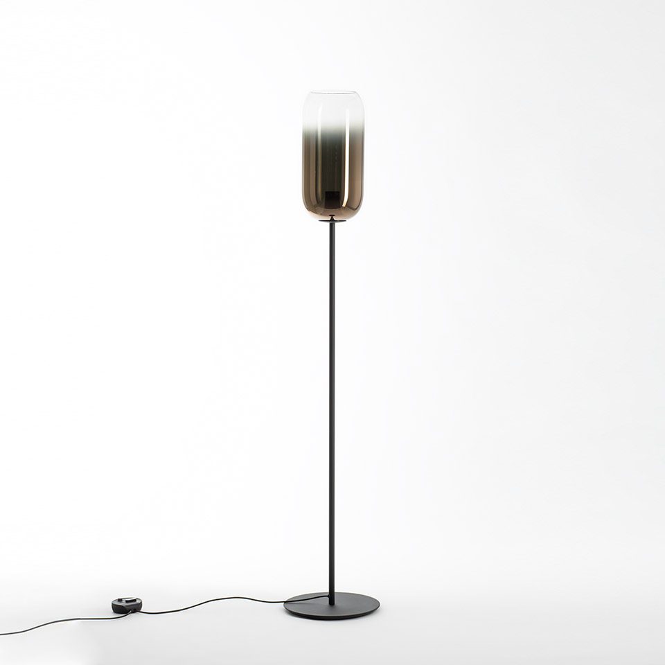 Artemide Gople floor lamp: tall black metal stem with round base, cylindrical gradient glass shade from clear top to bronze bottom