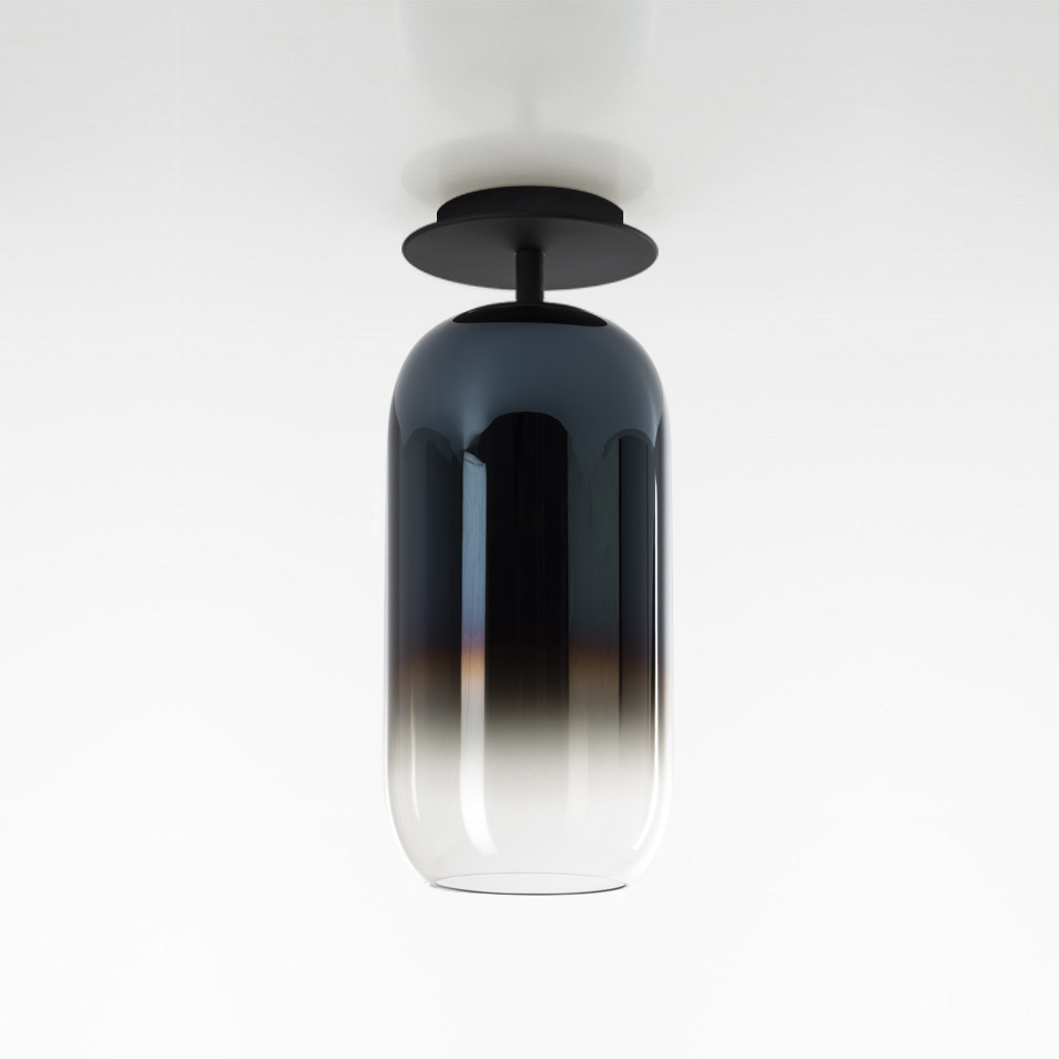 Artemide Gople ceiling lamp: capsule-shaped glass diffuser with dark-to-clear gradient, mounted on black metal ceiling plate