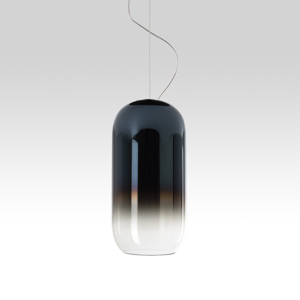 Artemide Gople pendant lamp: elongated capsule-shaped blown glass shade with dark blue-to-clear gradient, suspended by steel cables