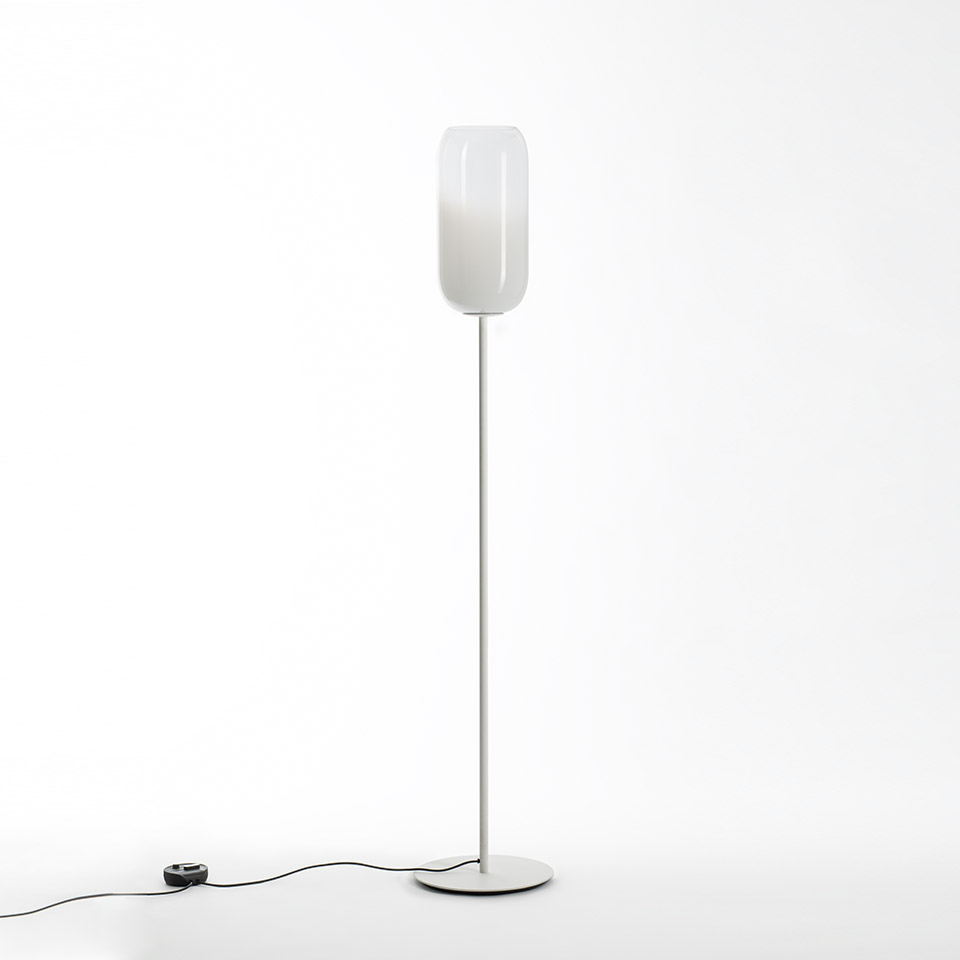 Artemide Gople floor lamp: tall slim white metal stem with round base, topped by an oval white blown glass diffuser