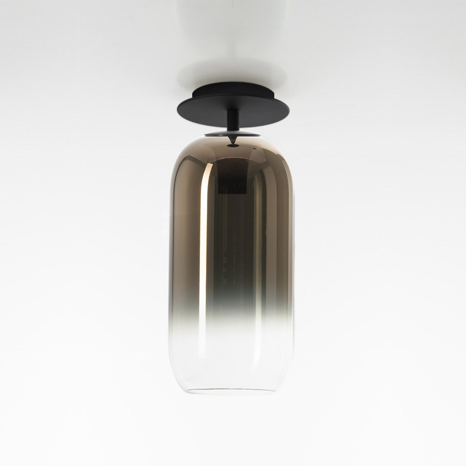 Artemide Gople ceiling lamp with elongated capsule-shaped glass shade, gradient from bronze to clear, black metal canopy