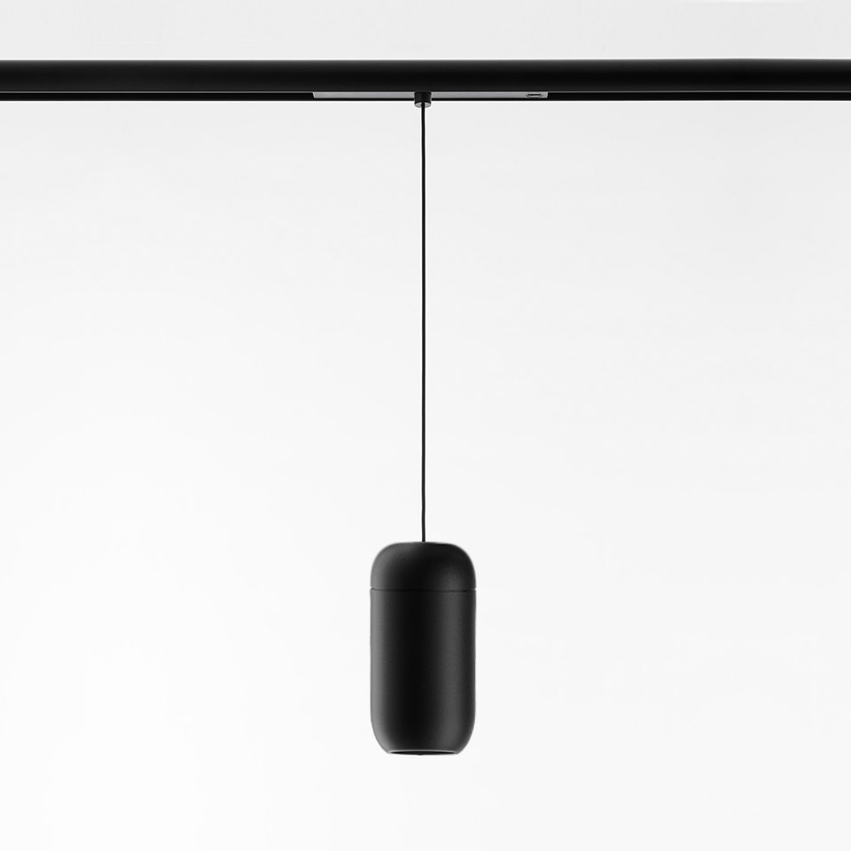 Gople System pendant lamp by Artemide: matte black capsule-shaped diffuser suspended from a black track rail by a thin black cable