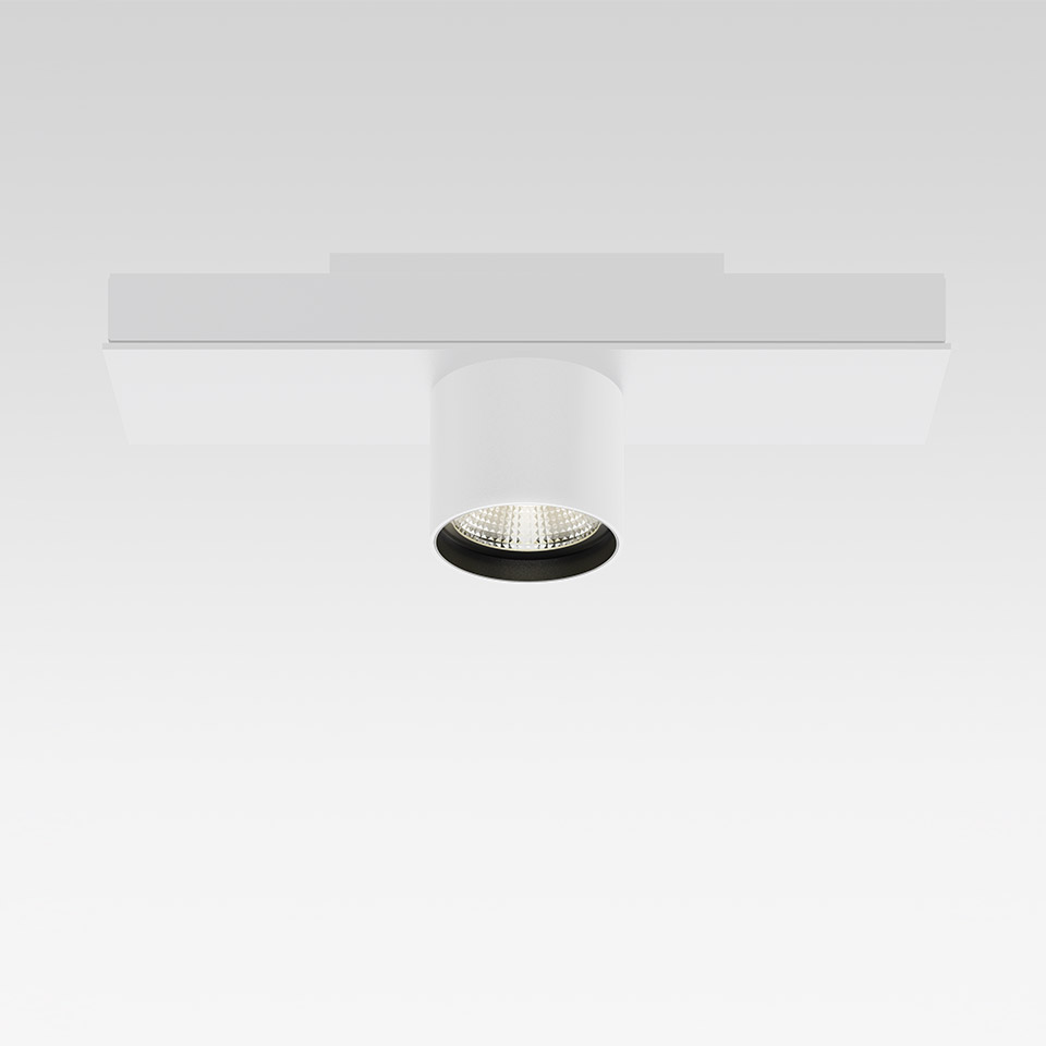 Artemide Hoy System: white cylindrical LED spotlight with black trim mounted on a flat white magnetic track rail