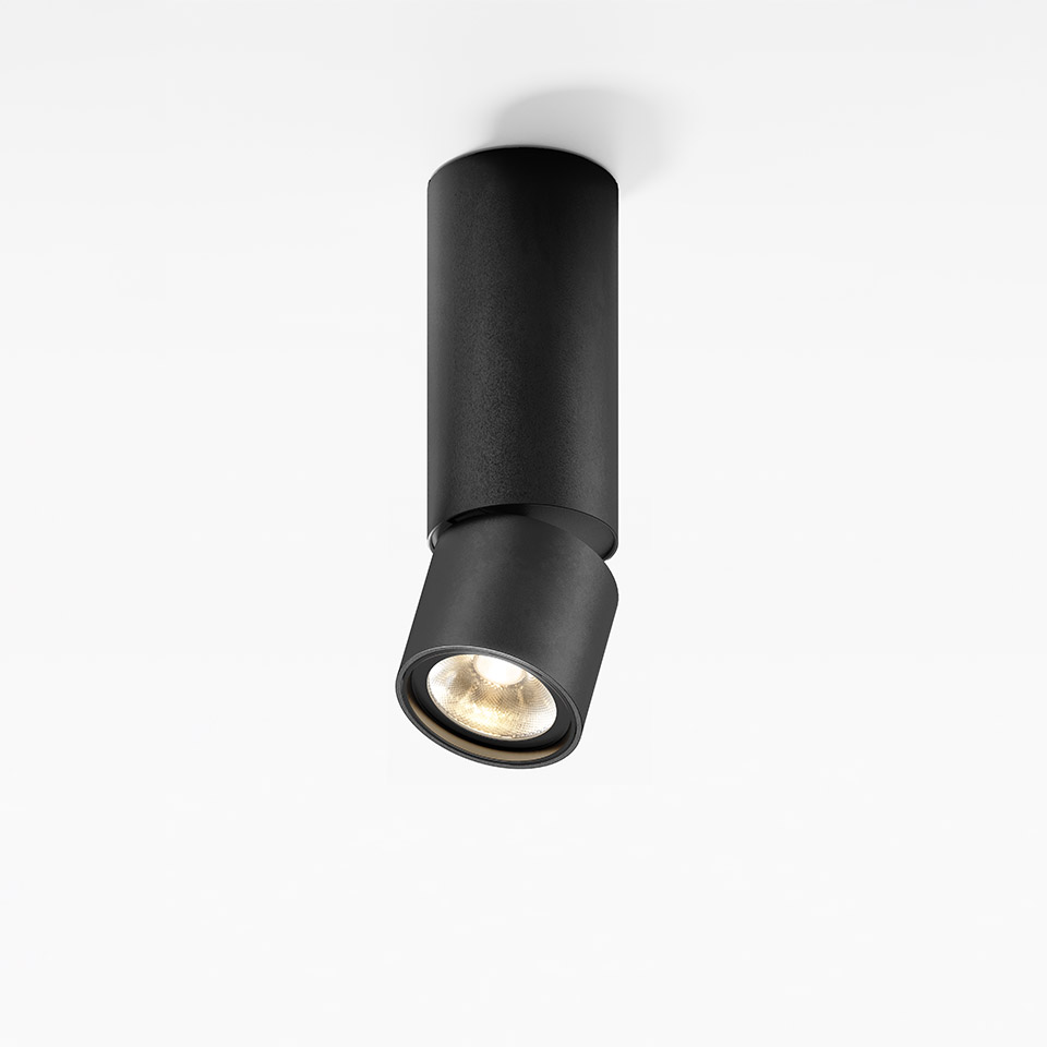 Artemide Hoy Spot SMD: black cylindrical ceiling spotlight with adjustable tilting head, emitting warm white light downward