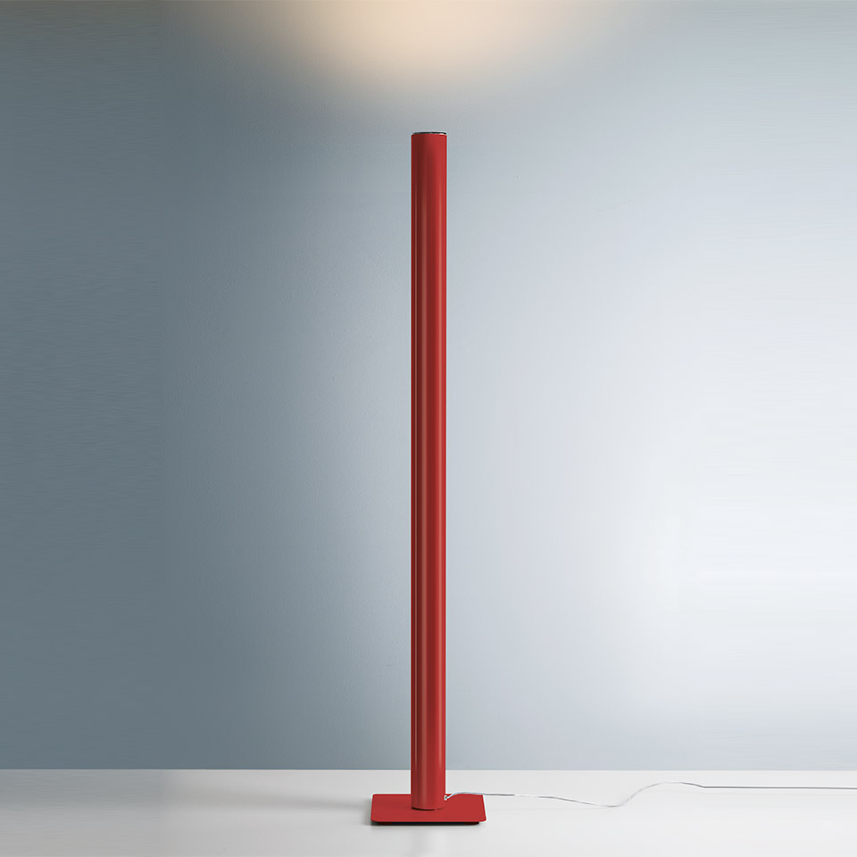 Artemide Ilio floor lamp in red, slim cylindrical column on square base, projecting indirect upward light onto ceiling