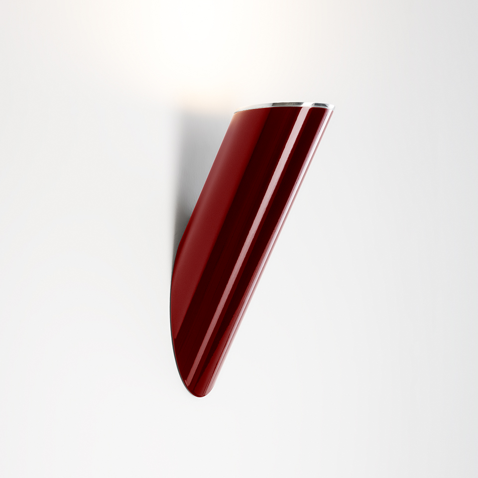 Artemide Ilio wall lamp, glossy deep red curved shell-shaped body directing light upward against white wall