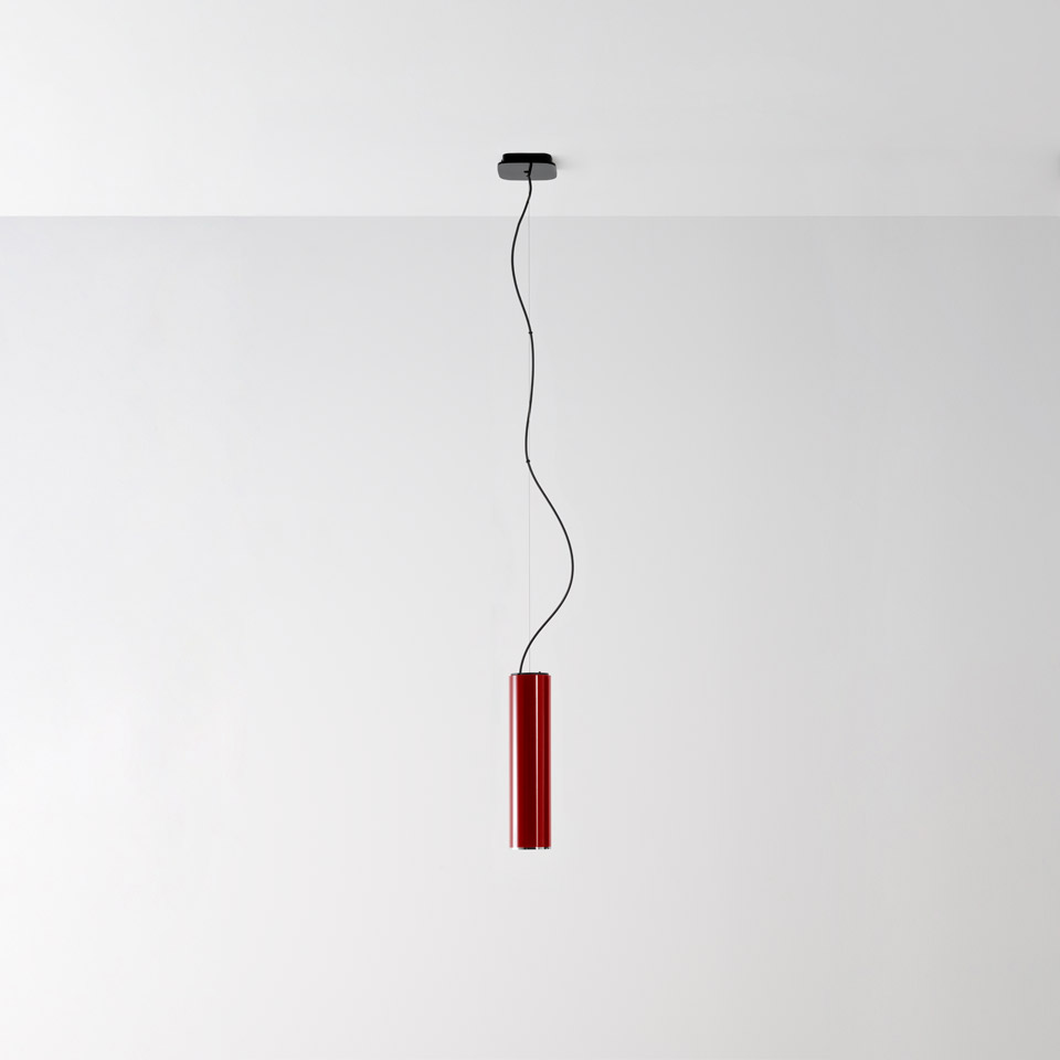 Ilio pendant lamp by Artemide: slim red cylindrical shade suspended from ceiling by a black cable with chrome canopy