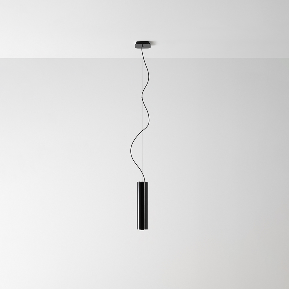 Artemide Ilio pendant lamp: slim black cylindrical body suspended from ceiling by a wavy black cable with canopy