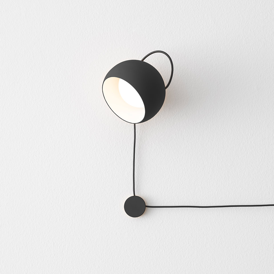 Artemide Ixa wall lamp in matte black, bowl-shaped shade with arched handle, adjustable head, dangling cord with circular counterweight