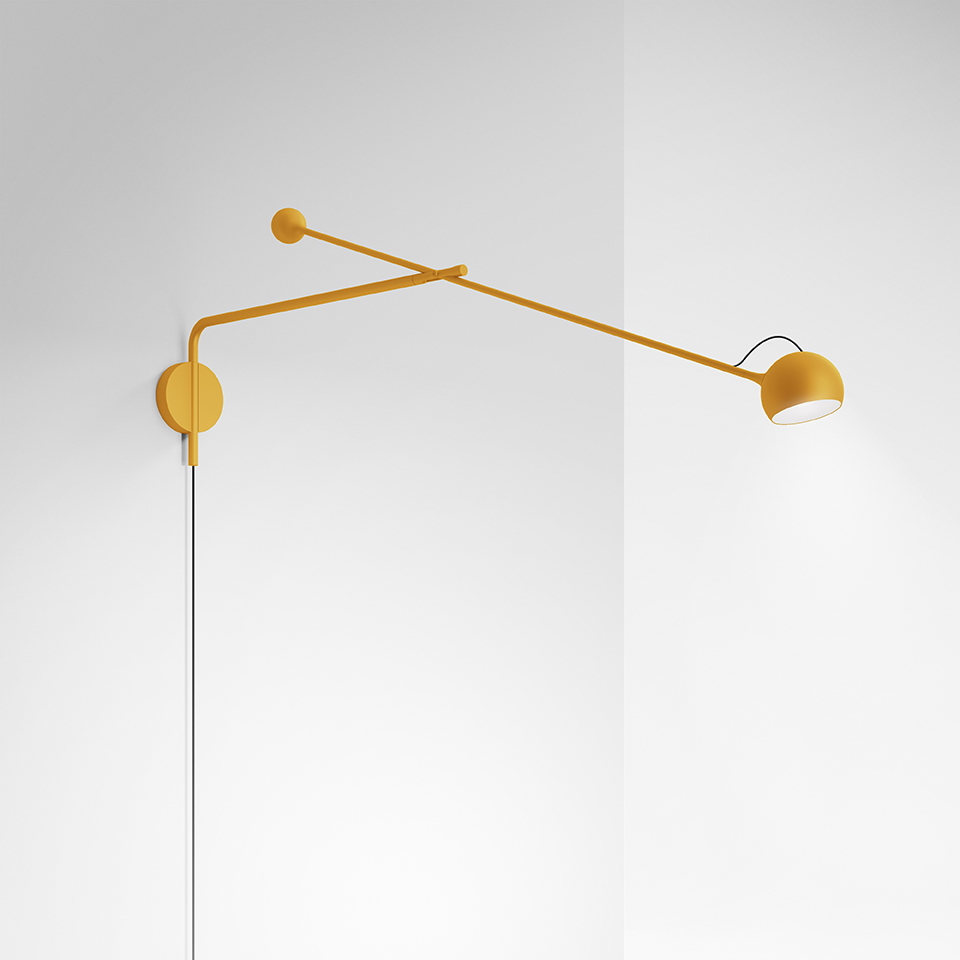 Artemide Ixa wall lamp in mustard yellow, featuring an adjustable double-arm with small spherical counterweight and a tilting bowl-shaped shade