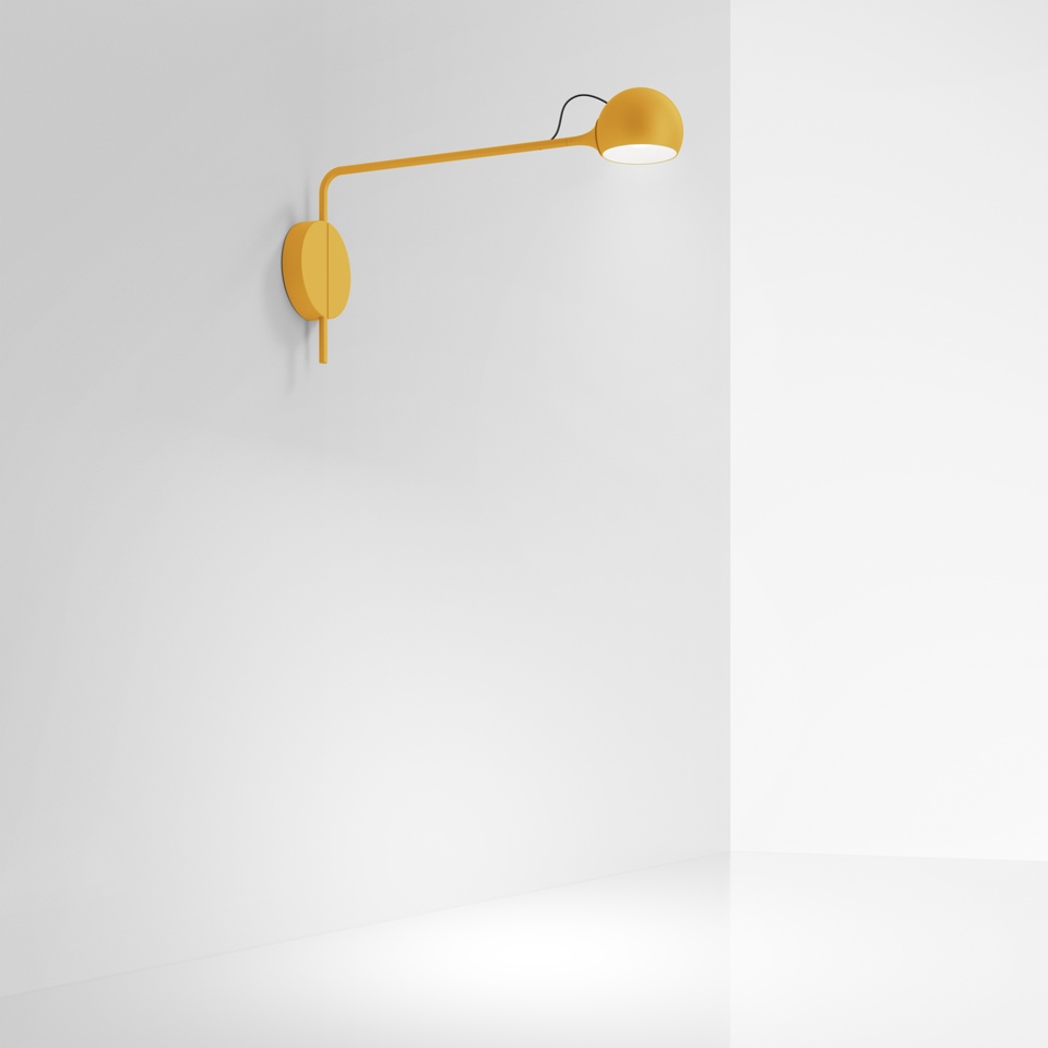 Artemide Ixa wall lamp in mustard yellow, featuring a long adjustable arm with a spherical LED head mounted on a round wall plate