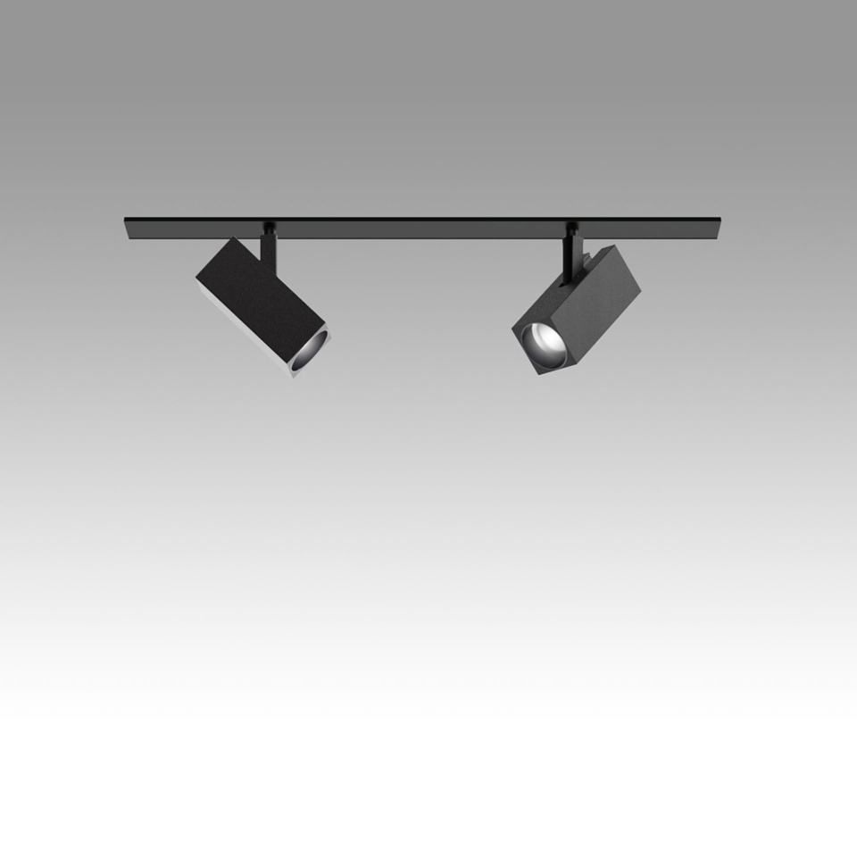 Artemide Katà Métron: two adjustable black square spotlights mounted on a ceiling track rail, one lit showing warm LED light