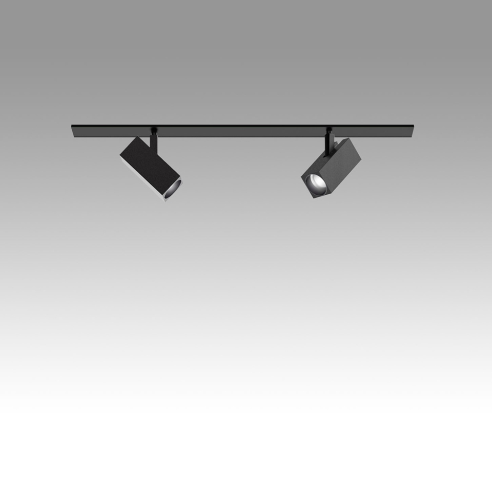 Artemide Katà Métron track system in black with two adjustable square spotlights mounted on a ceiling rail, one illuminated