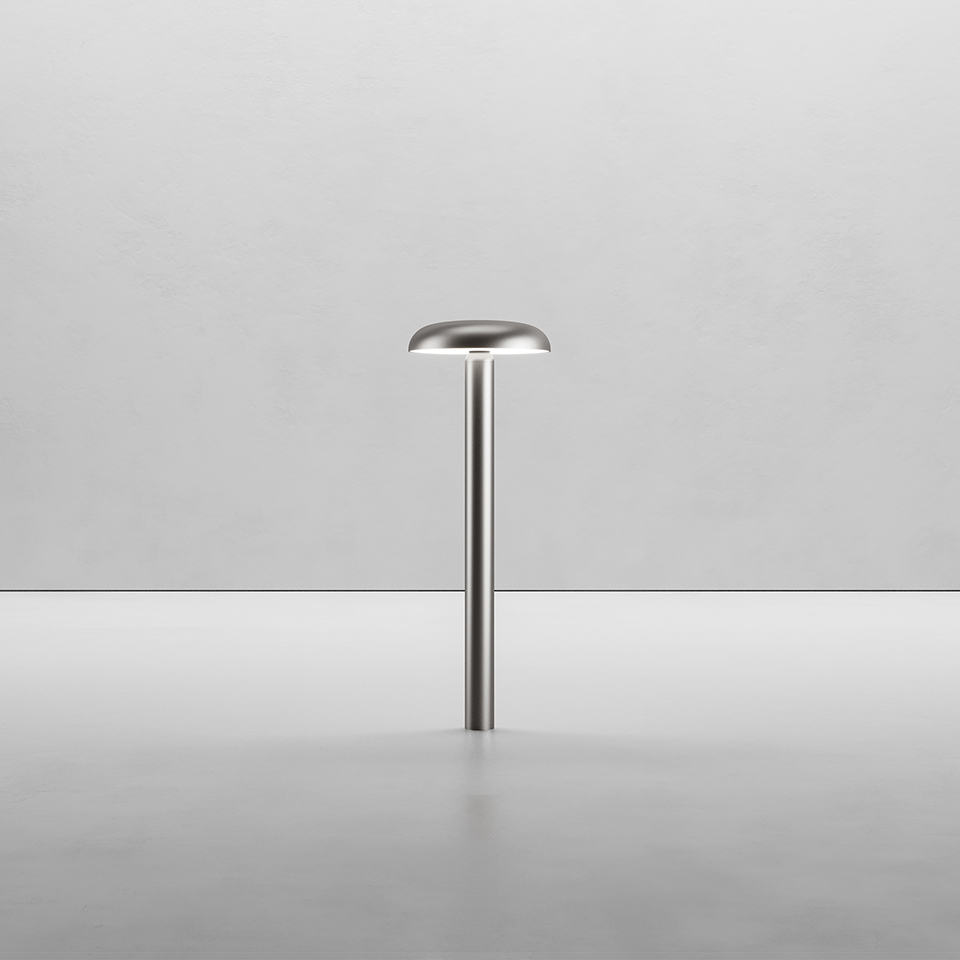 Artemide Knop table lamp in brushed steel, featuring a slim cylindrical stem topped with a flat mushroom-shaped diffuser