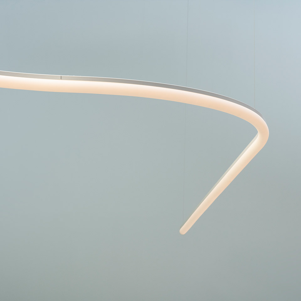 Artemide La Linea pendant lamp: close-up of a curved white LED profile forming an elliptical ring with tapered ends