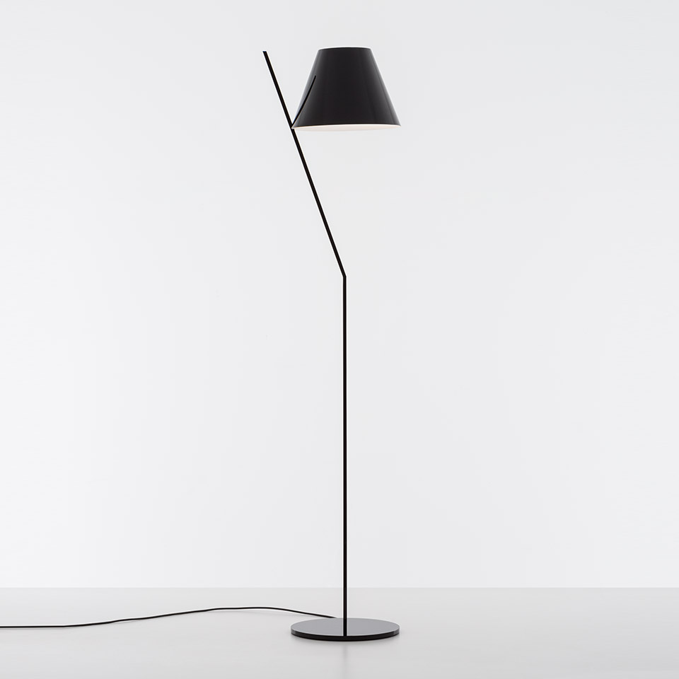 Artemide La Petite Floor lamp in black, featuring a slanted thin stem, round base, and conical shade with white interior
