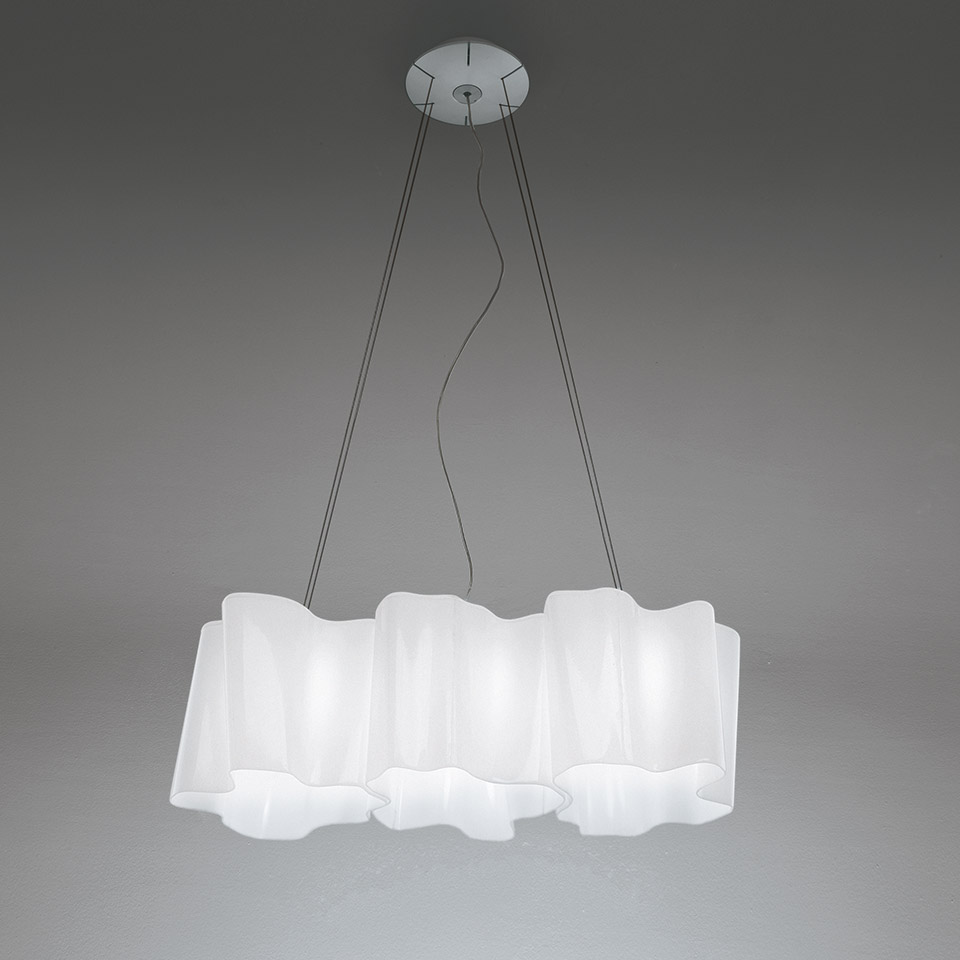 Artemide Logico suspension 3 in linea: three connected white diffusers in a row, hung by thin cables from a ceiling canopy