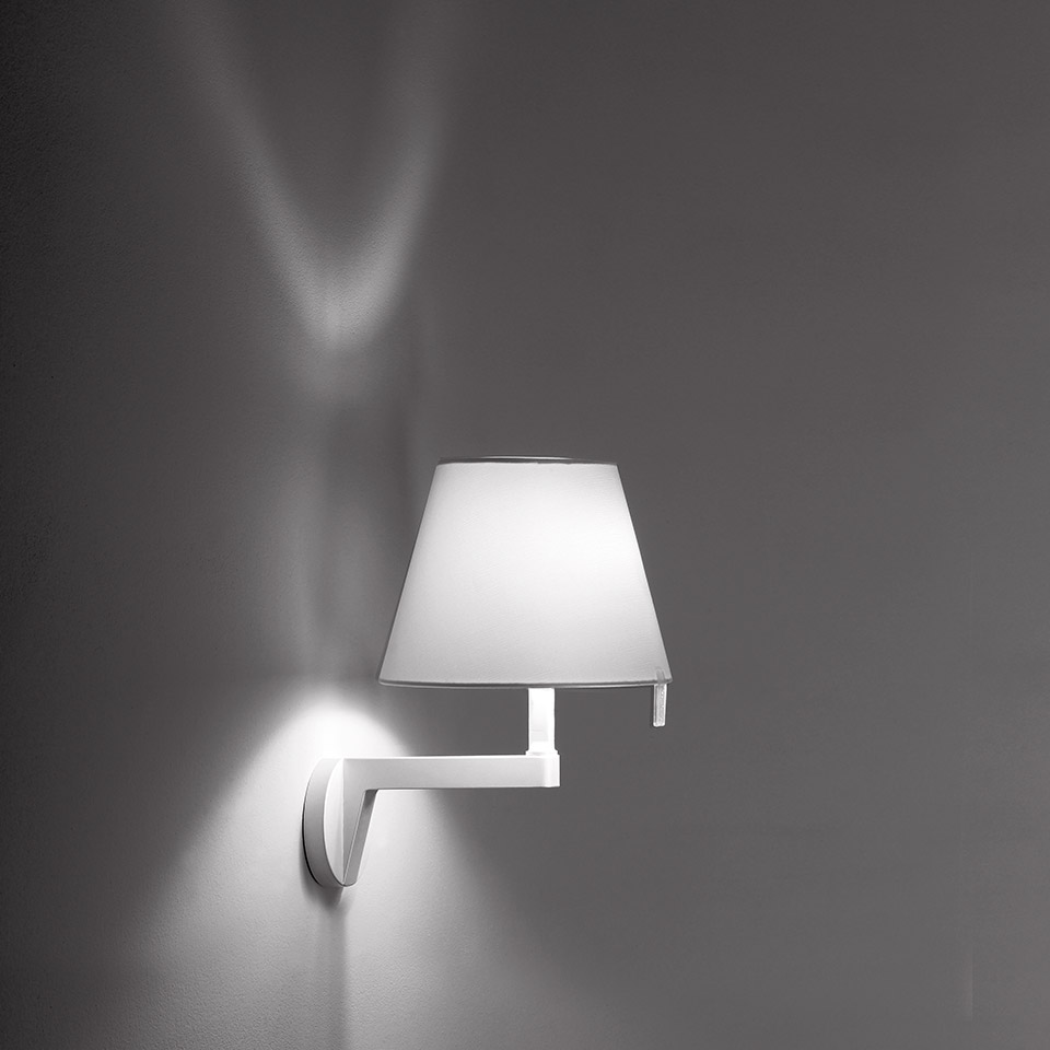 Artemide Melampo Parete wall lamp in white, with conical shade on angular arm, casting dramatic light patterns on the wall